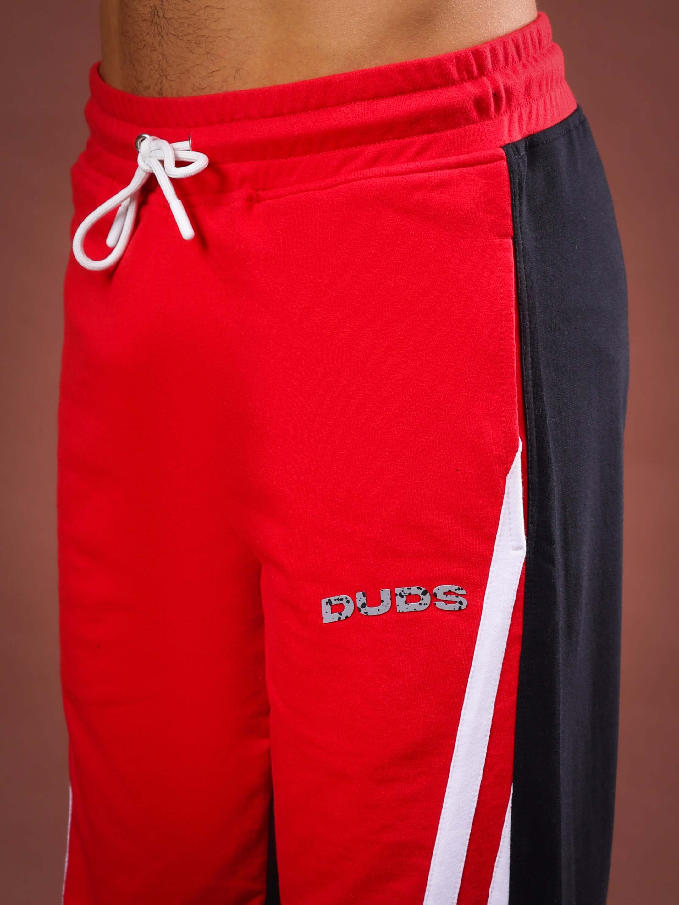 Red and black skater Korean baggy joggers with "DUDS" logo, featuring adjustable drawstring waist, perfect for casual fashion.