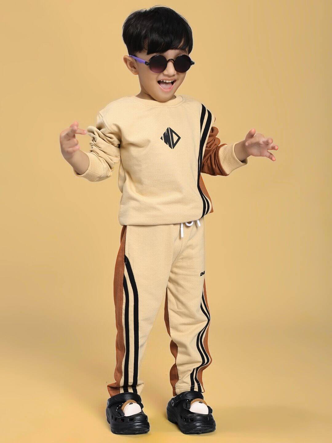 Child wearing the SKATER KOREAN CO-ORD FOR BOYS AND GIRLS CREAM BROWN in a playful pose, showcasing cream and brown color scheme.