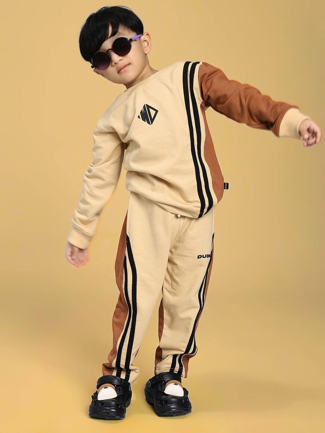 Child wearing SKATER KOREAN JOGGER FOR BOYS AND GIRLS CREAM BROWN with sunglasses, showcasing street style and playful functionality.