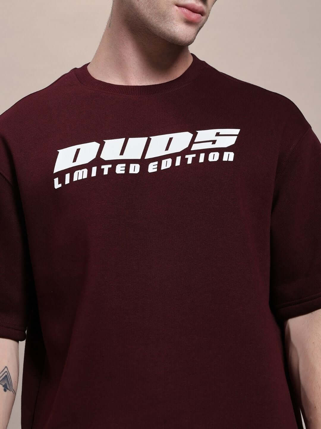 Person wearing SKODA FLEECE OVERSIZED T-SHIRT MAROON with bold graphic print