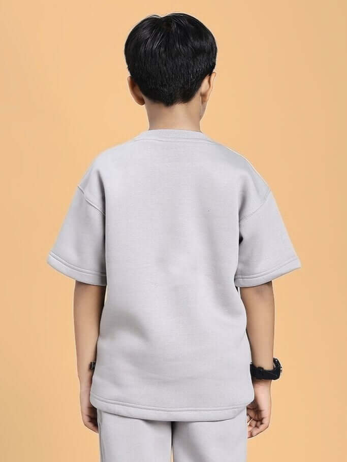 Child wearing SKODA FLEECE T-SHIRT FOR BOYS AND GIRLS GREY, showcasing back view of grey fleece shirt.