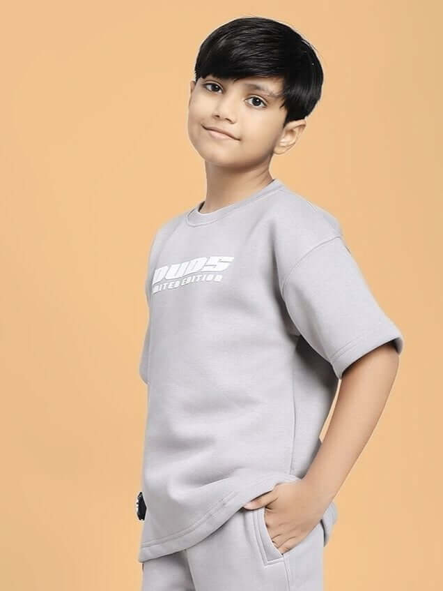 Child wearing SKODA FLEECE T-SHIRT FOR BOYS AND GIRLS GREY against beige background