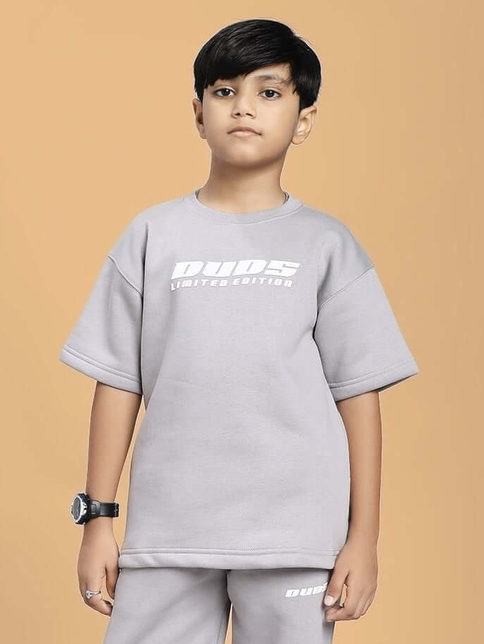 Boy wearing SKODA FLEECE T-SHIRT FOR BOYS AND GIRLS GREY on a beige background, showcasing a comfortable and stylish unisex design.