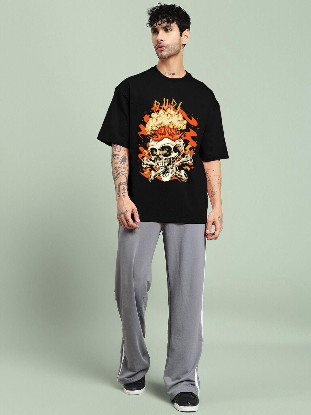 Person wearing SKULL BLAST FIRE PRINT OVERSIZED T-SHIRT BLACK with skull and fire graphic design, showcasing bold street fashion.