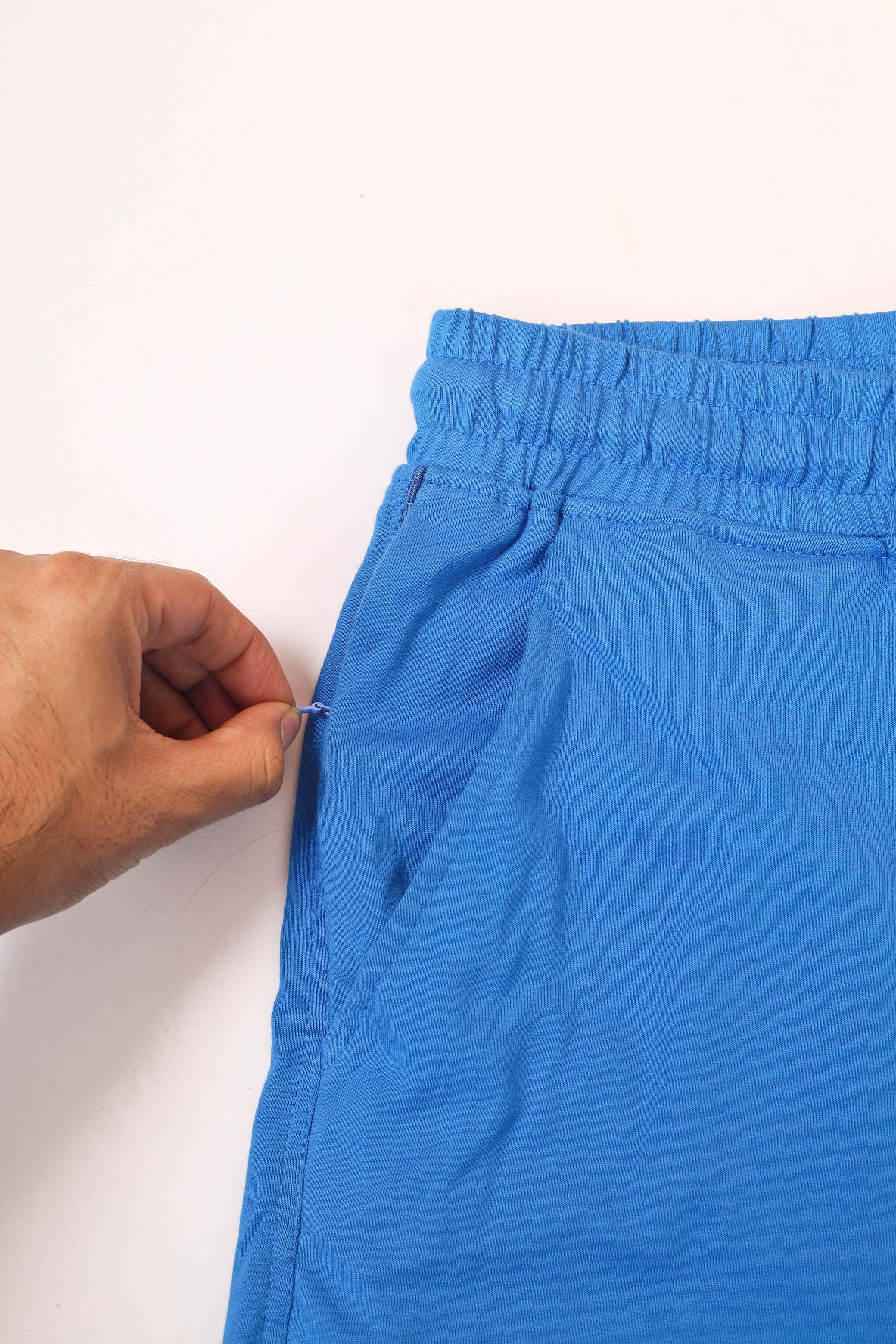 Close-up of SKULL BUTTERFLY REGULAR FIT SHORTS BLUE showing elastic waistband and side pocket detail.