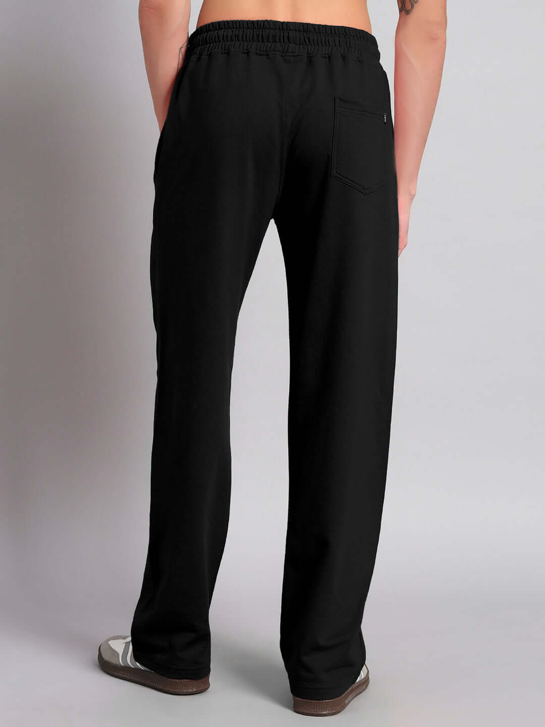 Back view of black relaxed fit jogger pants, showcasing comfortable design and elastic waistband, suitable for custom sizing.
