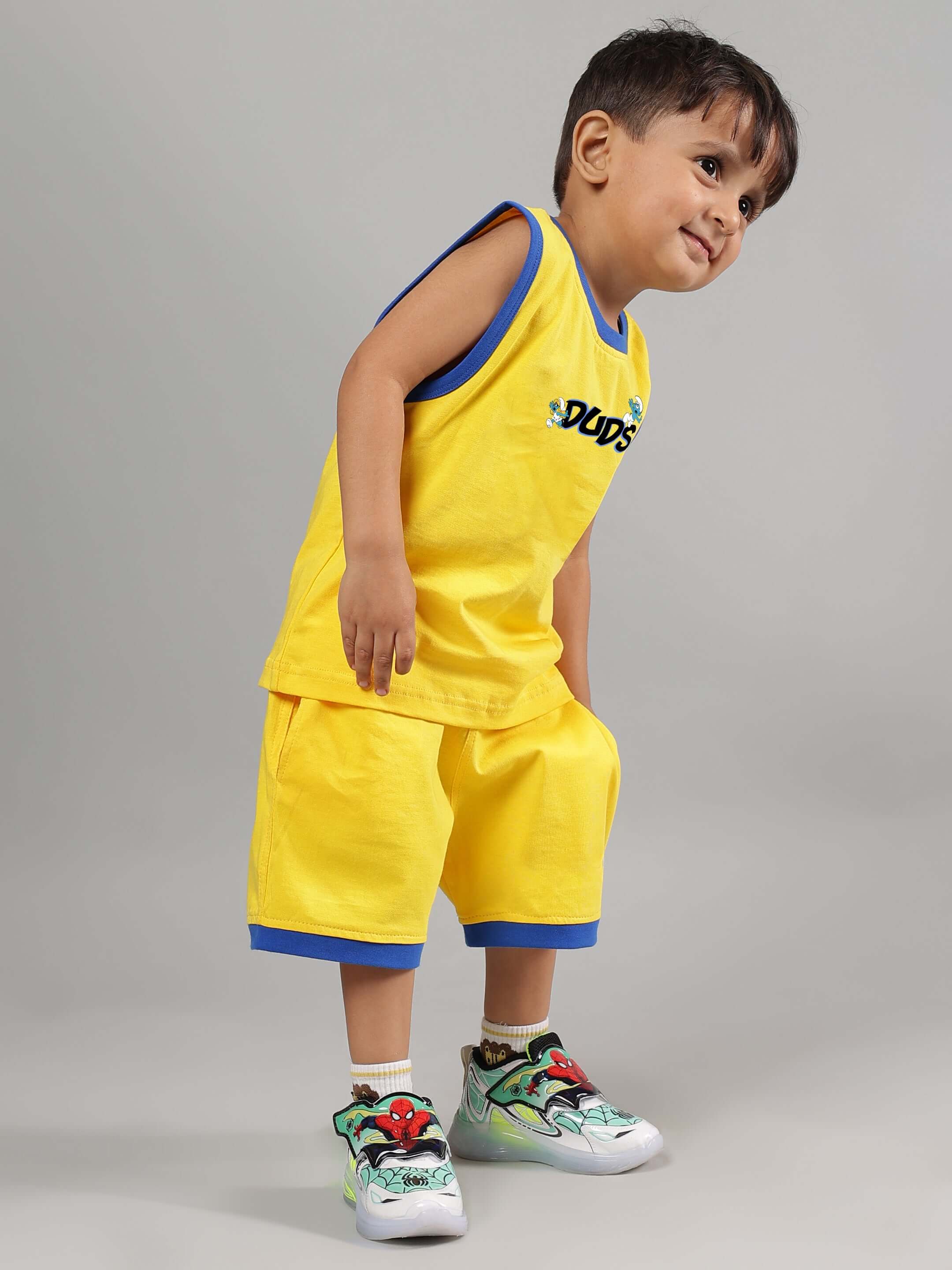 Child wearing SMURFS HOME CO-ORD FOR BOYS GIRLS YELLOW set, smiling in vibrant yellow outfit, soft cotton fabric, playful and comfortable design.