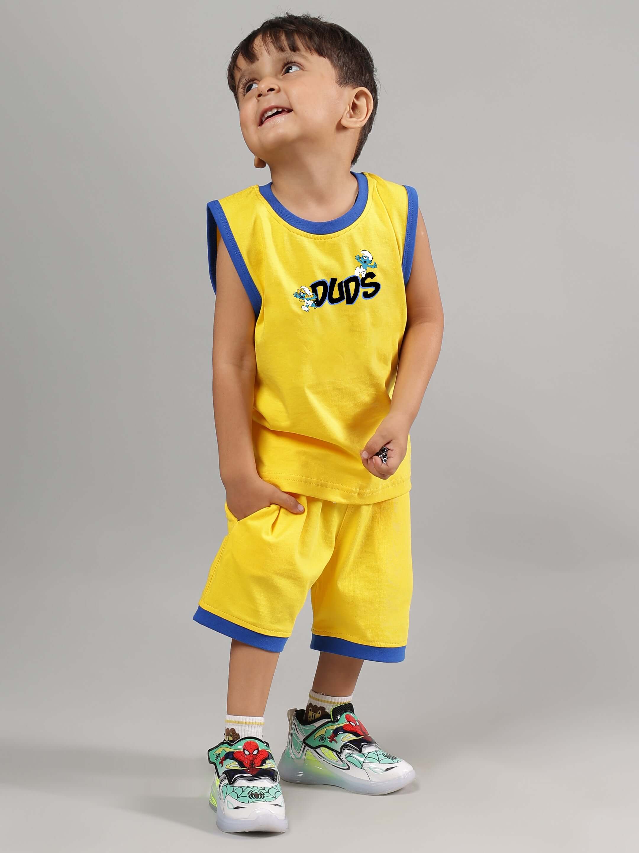Child wearing SMURFS HOME CO-ORD FOR BOYS GIRLS YELLOW outfit, featuring a bright yellow t-shirt and shorts with blue details.