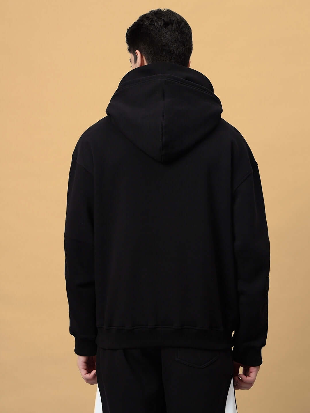 Back view of SNIPPER COTTON FLEECE HOODIE BLACK on model showing hood and relaxed fit design