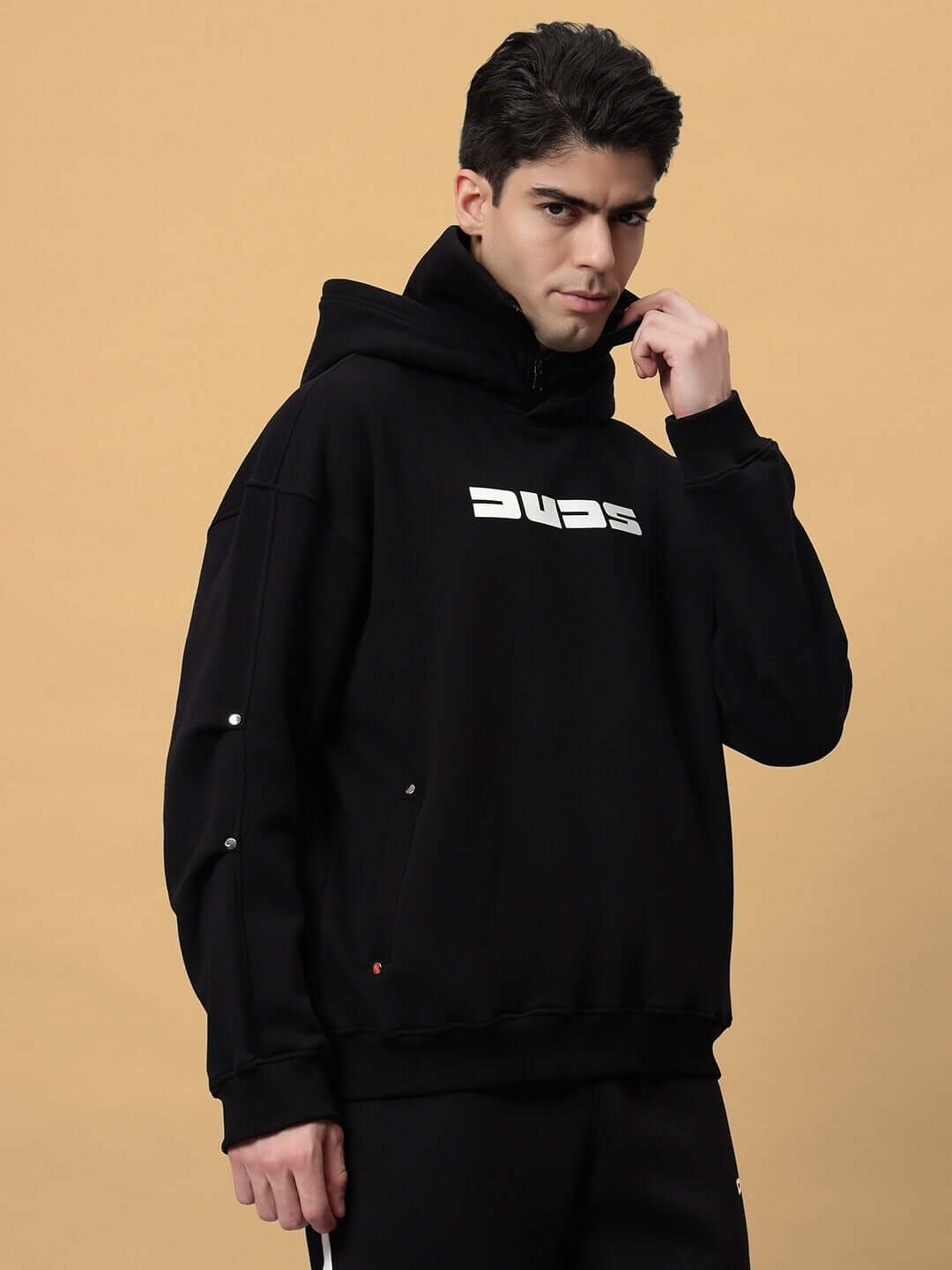 Model wearing SNIPPER COTTON FLEECE HOODIE BLACK with logo, showcasing streetwear style and comfort.