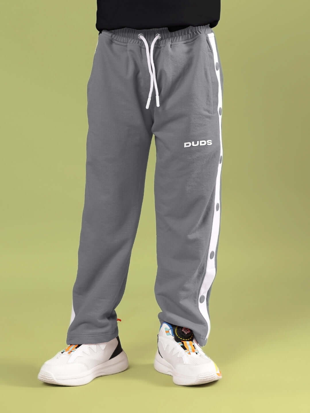 Child wearing SNOOPY RIMIX CO-ORD FOR BOYS & GIRLS BLACK GREY with drawstring pants and DUDS logo.