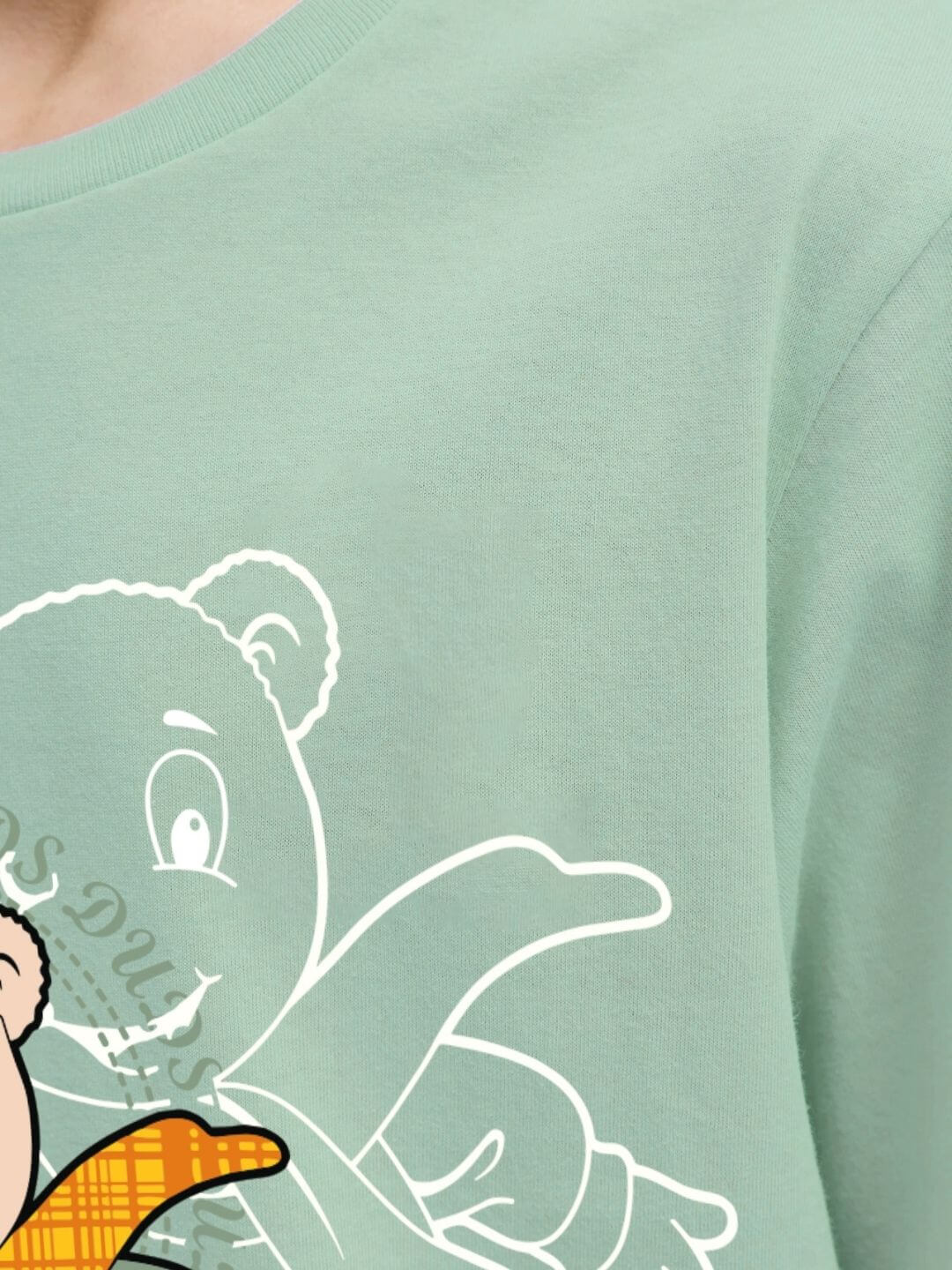 Close-up of SOCCER PRINTED T-SHIRT FOR BOYS AND GIRLS LIGHT GREEN with playful graphic design in soft cotton fabric.