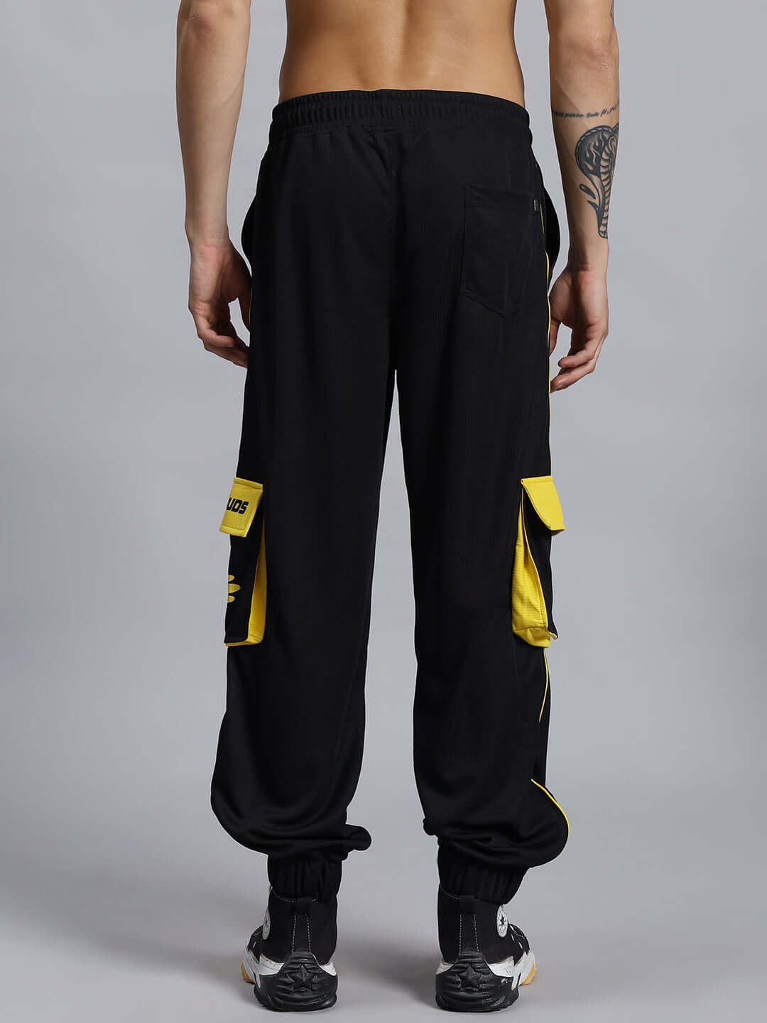 SOCCER REGULAR FIT CARGO JOGGER BLACK view of black soccer regular fit cargo joggers with yellow pocket accents, designed for a comfortable fit and customizable size options.