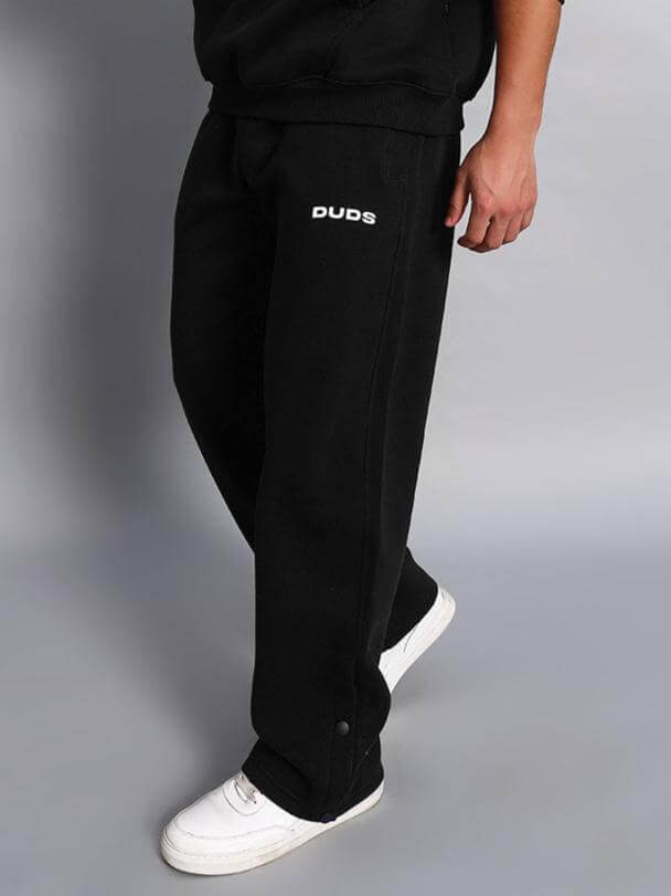 Person wearing WEARDUDS SOOTY FLEECE PANT BLACK with 'DUDS' logo, displaying comfortable fit and style.