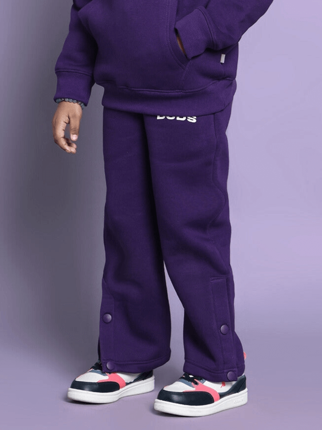 Child wearing purple Sooty fleece pants suitable for boys and girls, featuring comfortable fit and button details.