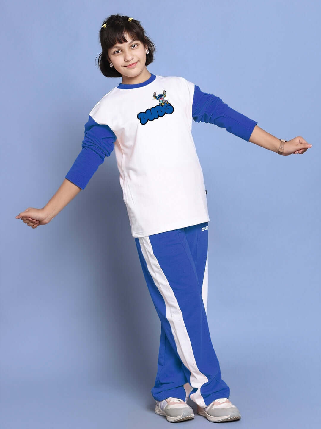 Child wearing SORE oversized white-blue co-ord set, unisex joggers with red-white contrast, elasticated waistband. Fashionable and comfortable.
