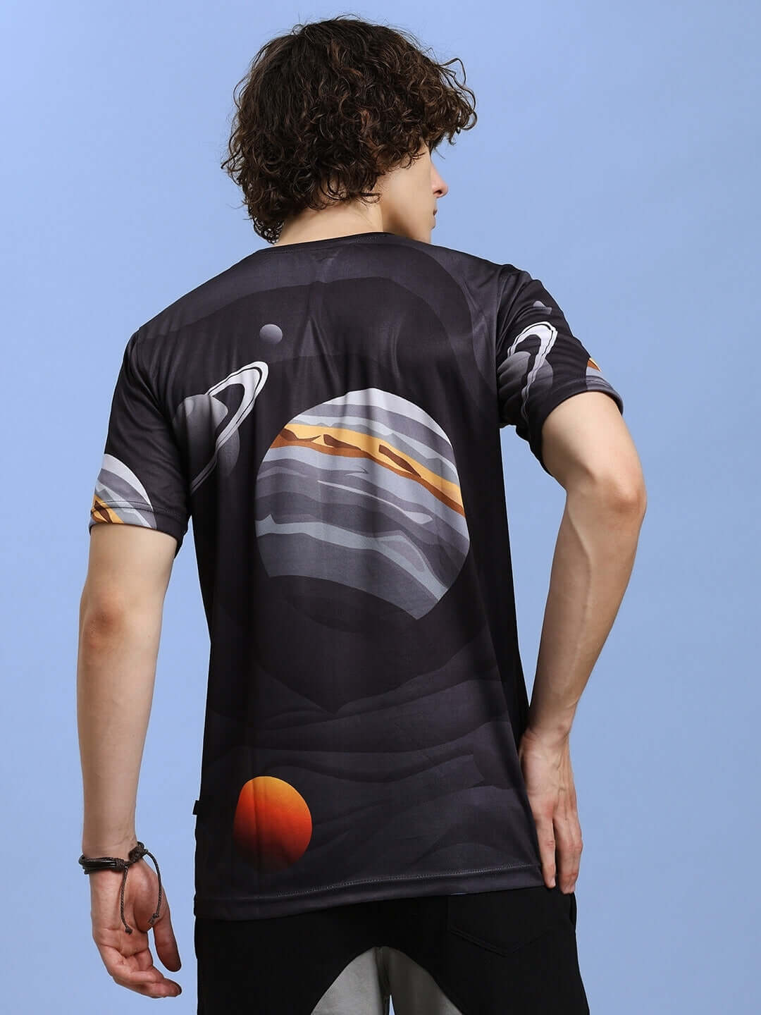 Back view of man wearing a SPACE FANTASY printed black T-shirt with planets, made from sports polyester.