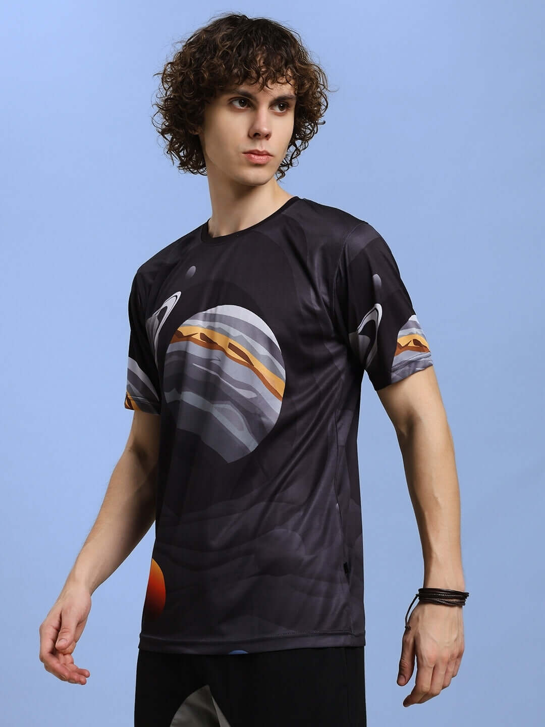 Model wearing a black SPACE FANTASY printed T-shirt in sports polyester, showcasing a cosmic design. Perfect for casual wear.