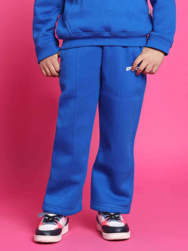 Child wearing Spiderrobo blue oversized hoodie and pants, standing against a pink background.