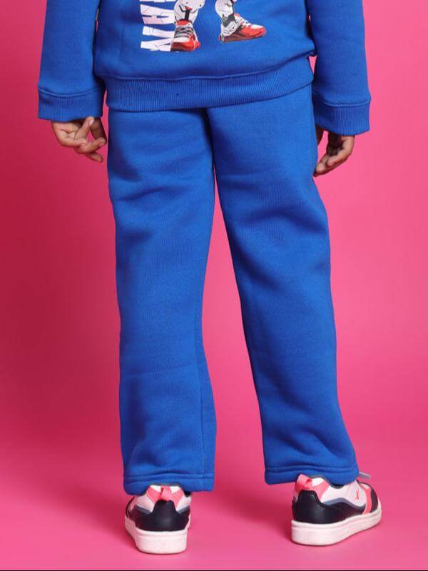 Child wearing SPIDERROBO blue fleece pants for boys and girls, showing back view against a pink background.