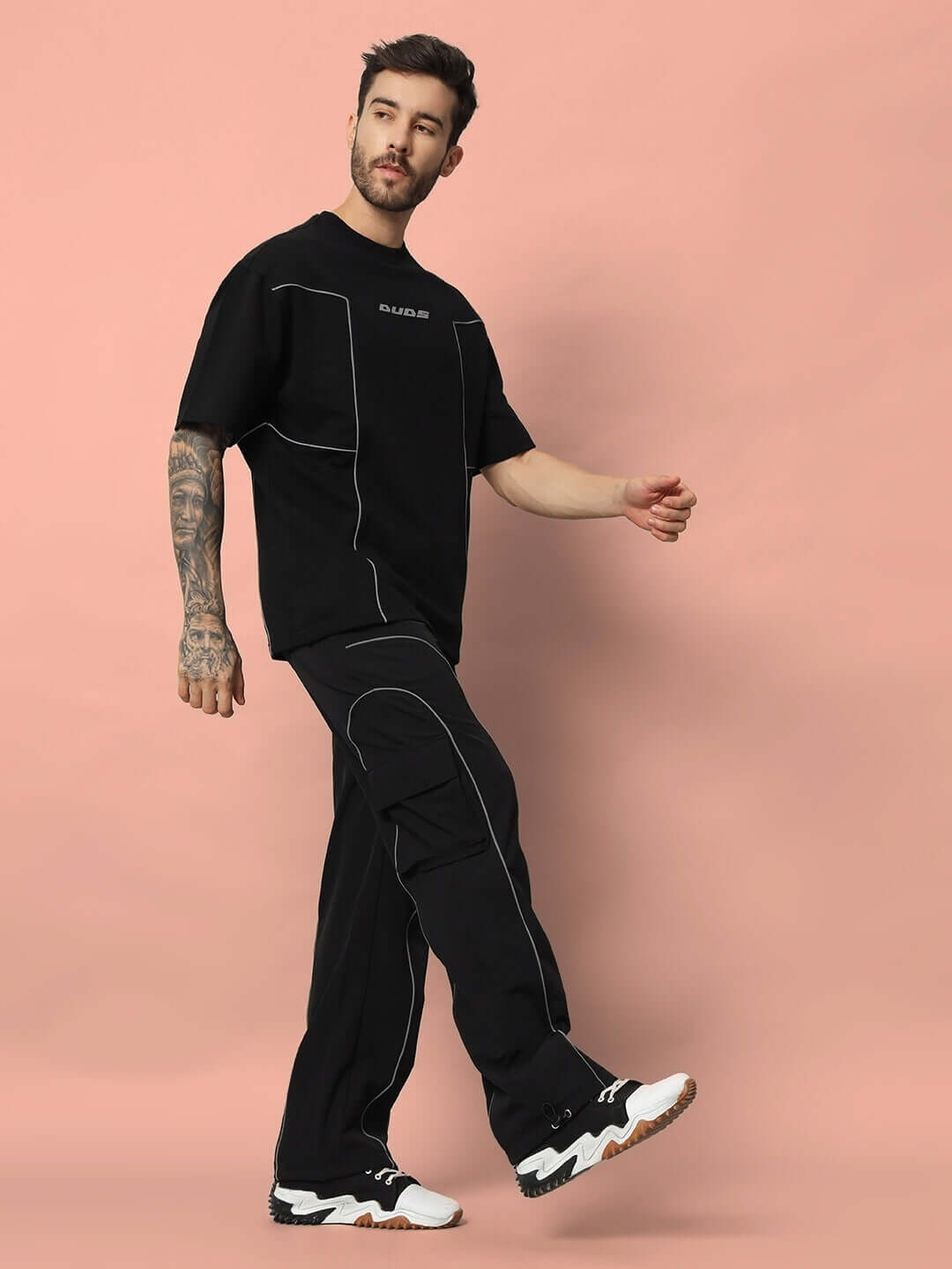 Model wearing black oversized faux reflector t-shirt made from premium cotton French terry, styled casually with matching pants.