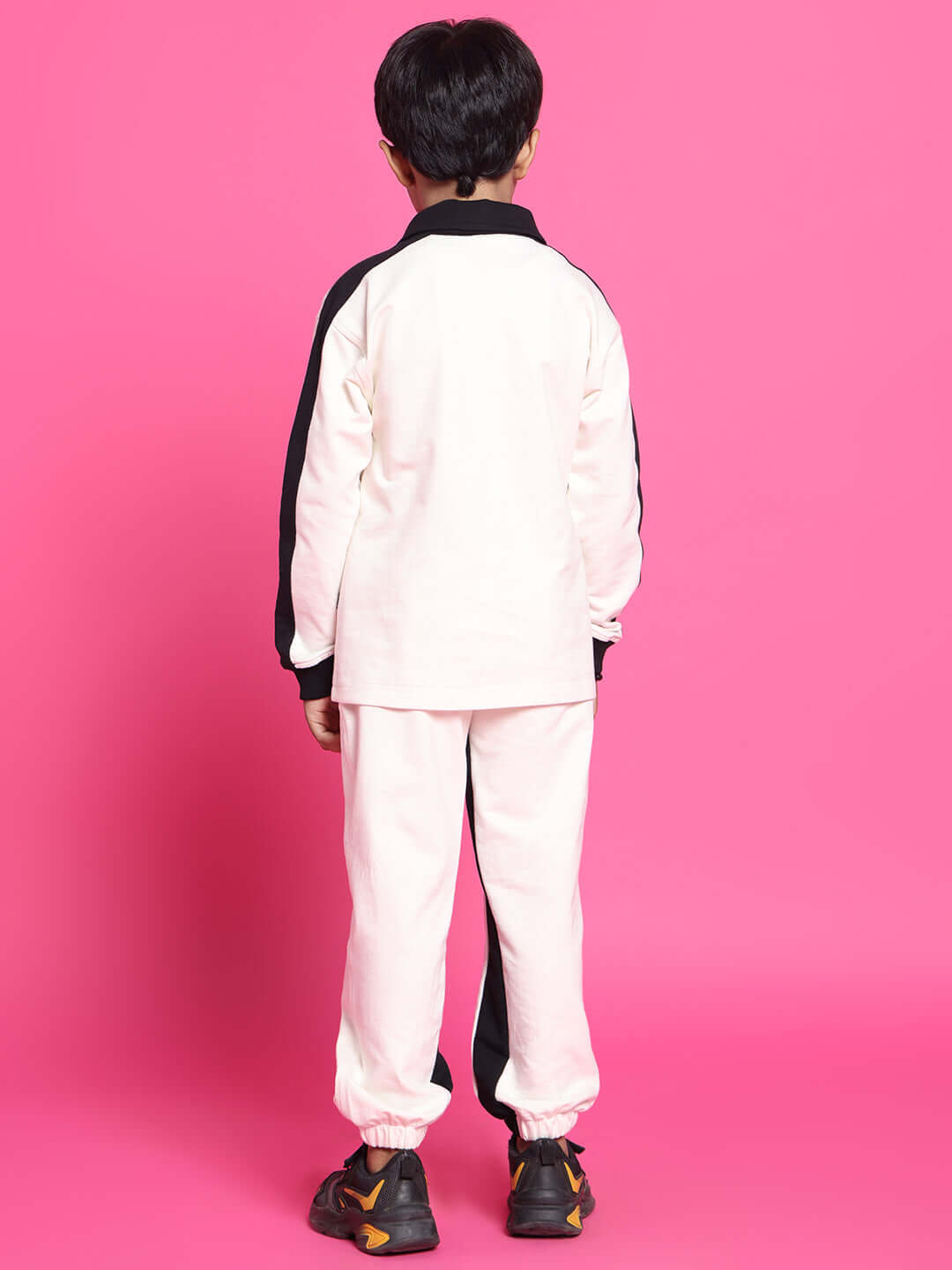 Child wearing SPLINTER OVERSIZED CO-ORD SET FOR BOYS GIRLS OFF WHITE BLACK on pink background