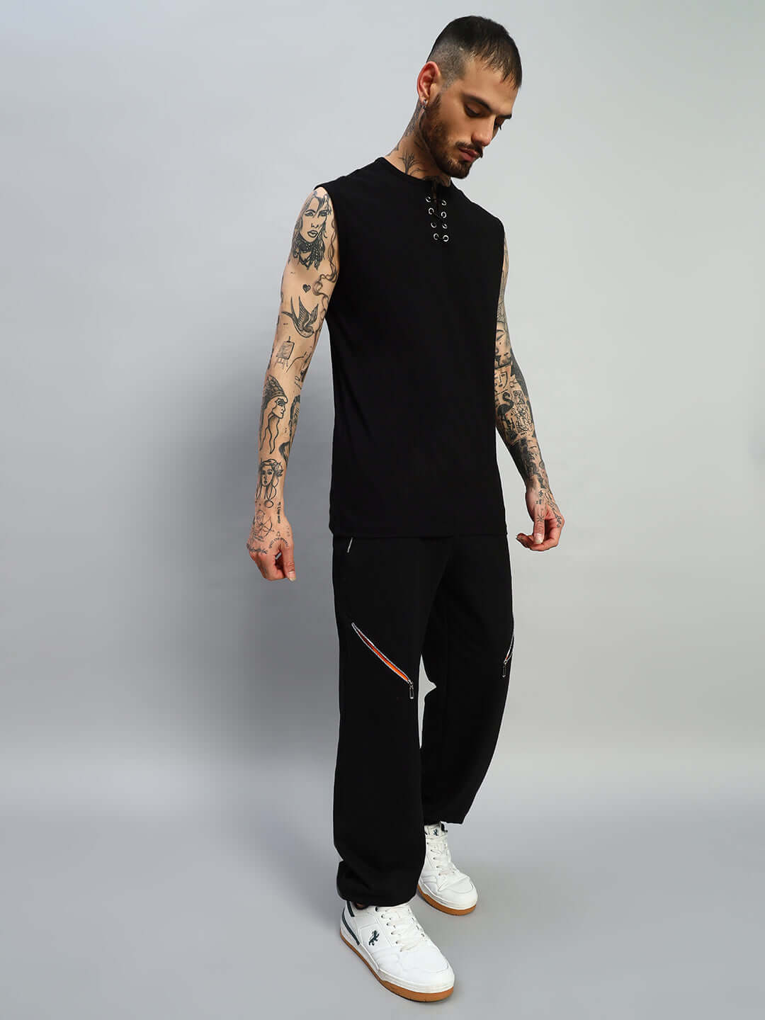 Model wearing black Squall Joggers by DUDS, showcasing relaxed fit and custom fit option, ideal for casual wear with white sneakers.