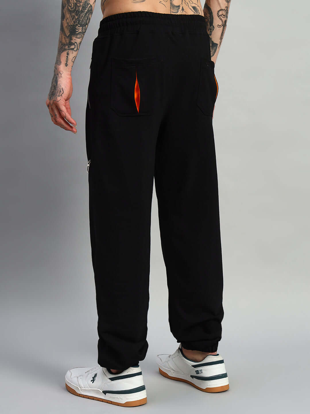 Back view of black SQUALL joggers, made-to-order with custom fit option, worn by a person in white sneakers.