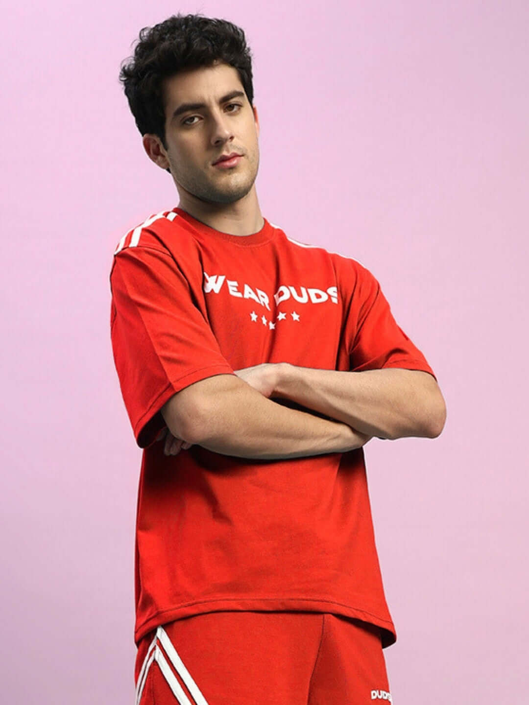 Model wearing STAR JUMPER OVER-SIZED T-SHIRT RED with streetwear style and bold graphic detail.