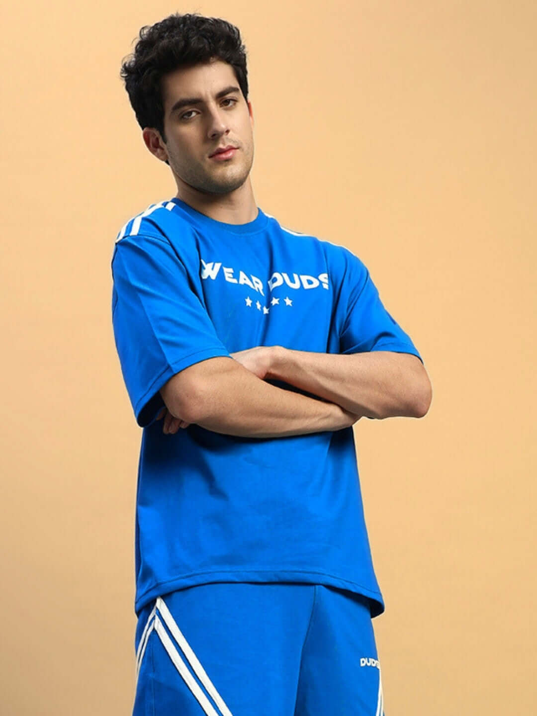 Man wearing STAR JUMPER OVER-SIZED T-SHIRT ROYAL BLUE in casual streetwear fashion, featuring relaxed silhouette and premium cotton.