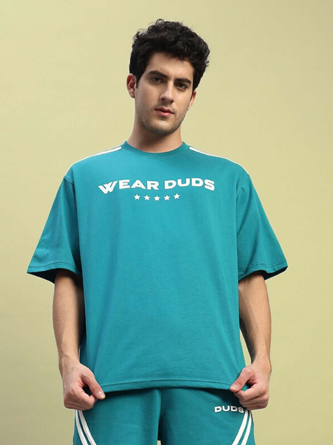 Person wearing STAR JUMPER OVER-SIZED T-SHIRT TEAL showcasing style and comfort.