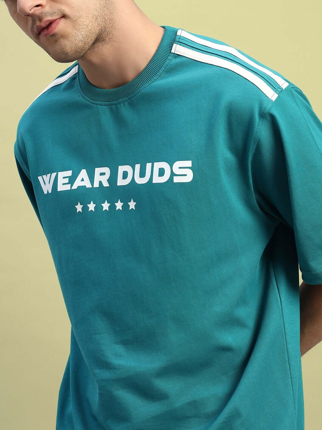 Man wearing STAR JUMPER OVER-SIZED T-SHIRT TEAL, showcasing breathable cotton material and casual streetwear style.