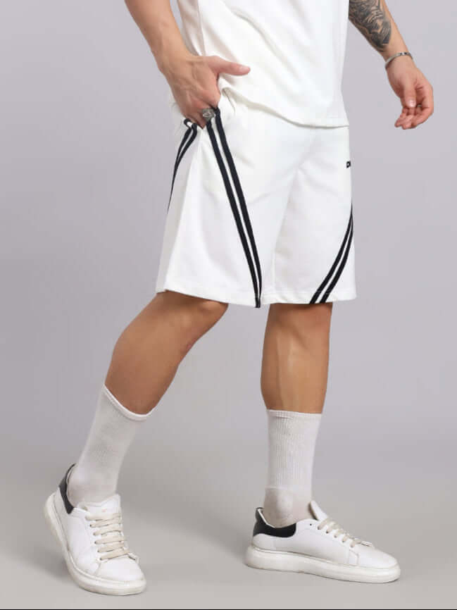Man wearing STAR JUMPER REGULAR FIT SHORTS OFF WHITE with casual sneakers and socks, showcasing style and comfort in everyday wear.