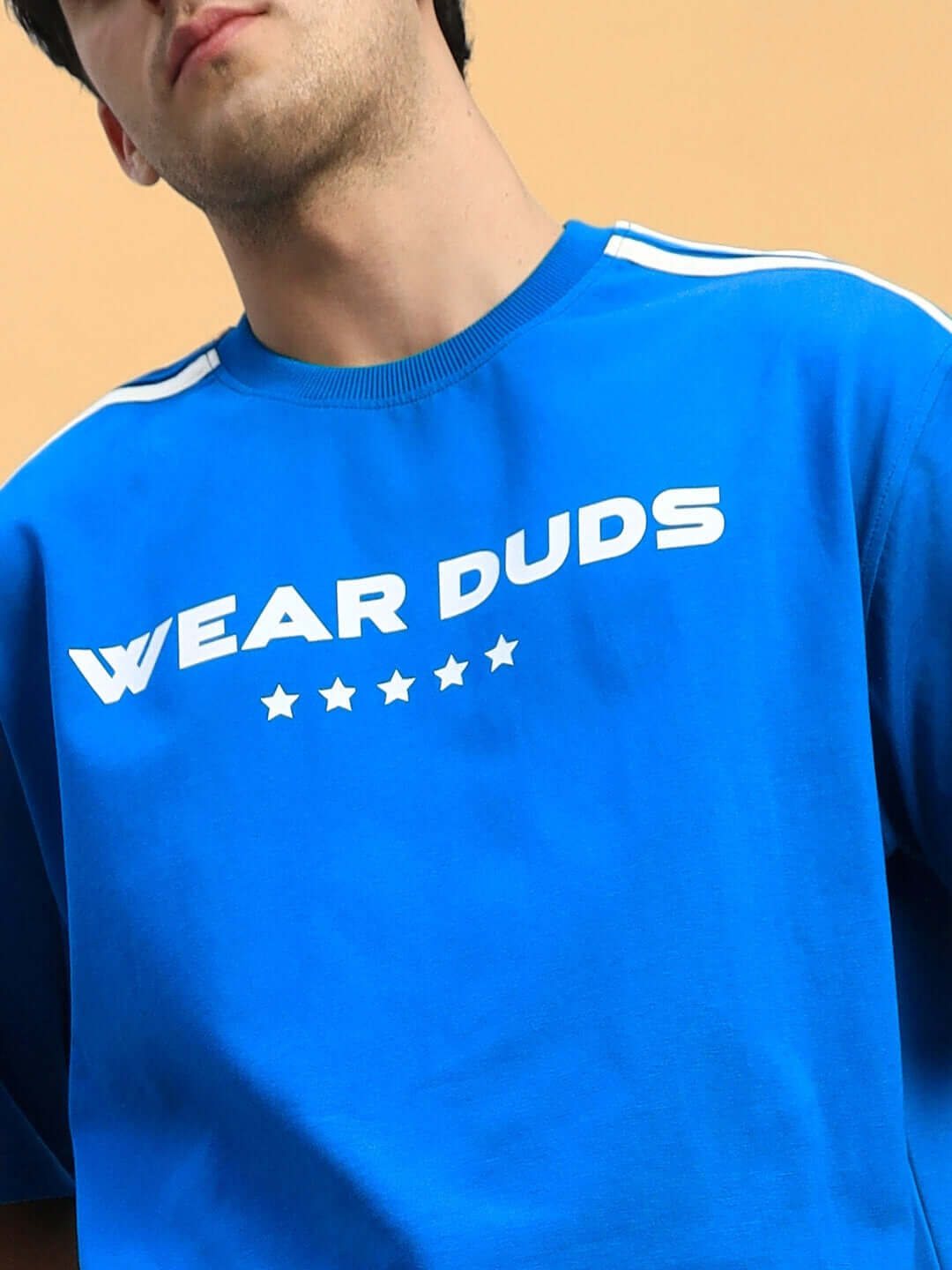 Man wearing blue STAR JUMPER SUMMER CO-ORD SET ROYAL BLUE t-shirt with 'Wear Duds' print and star design