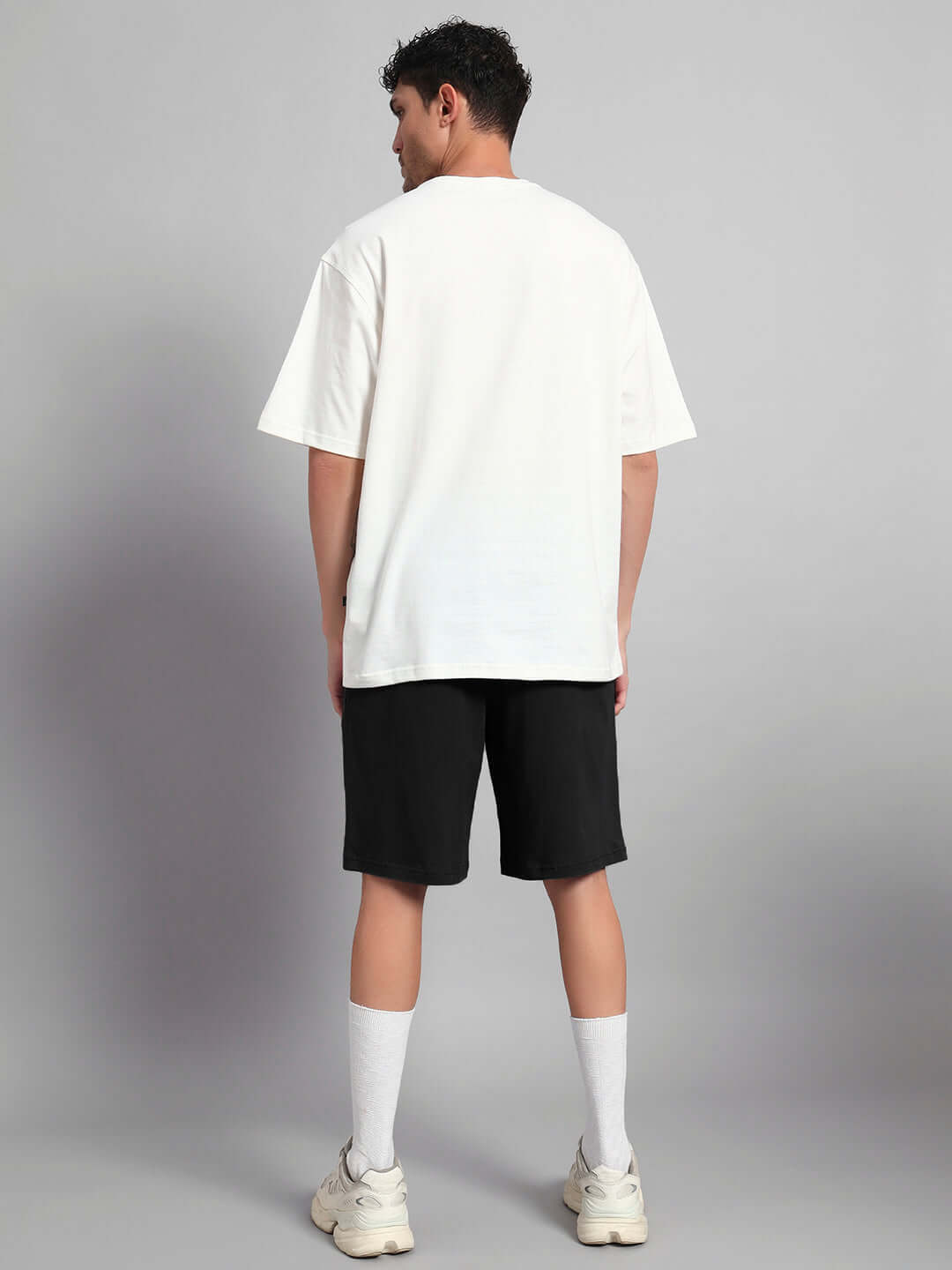 Back view of model wearing STARRY SKY CO-ORD SET OFF WHITE BLACK, showcasing versatile outfit for kids with playful prints.