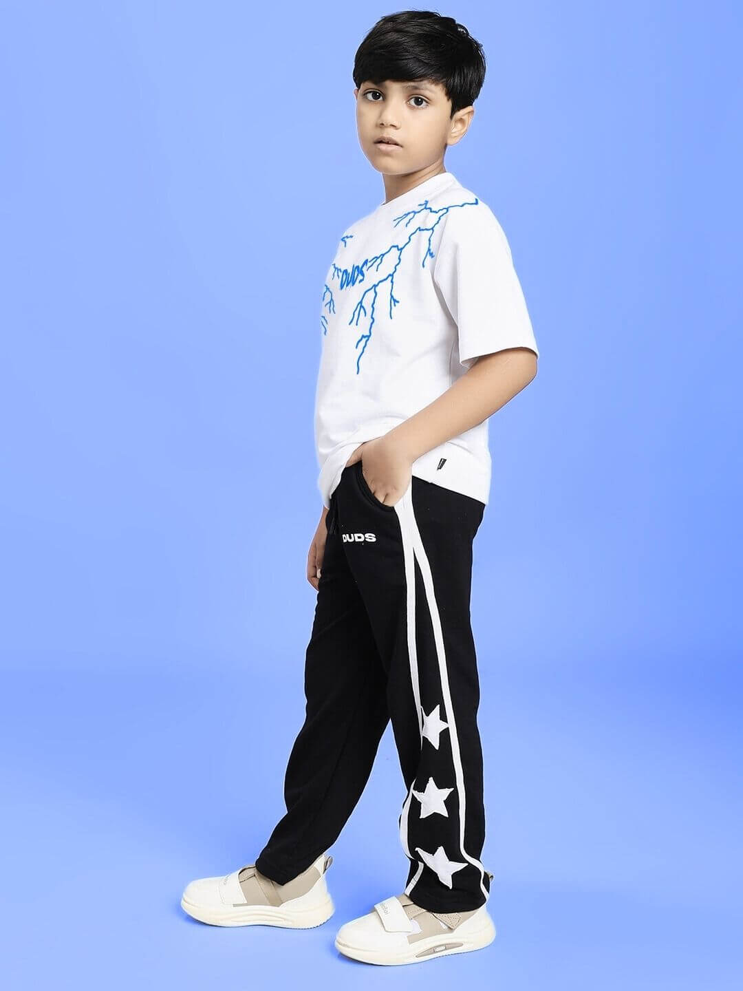 STELLAR RELAXEDFIT JOGGER FOR BOYS AND GIRLS BLACK worn by a child standing in a studio background.