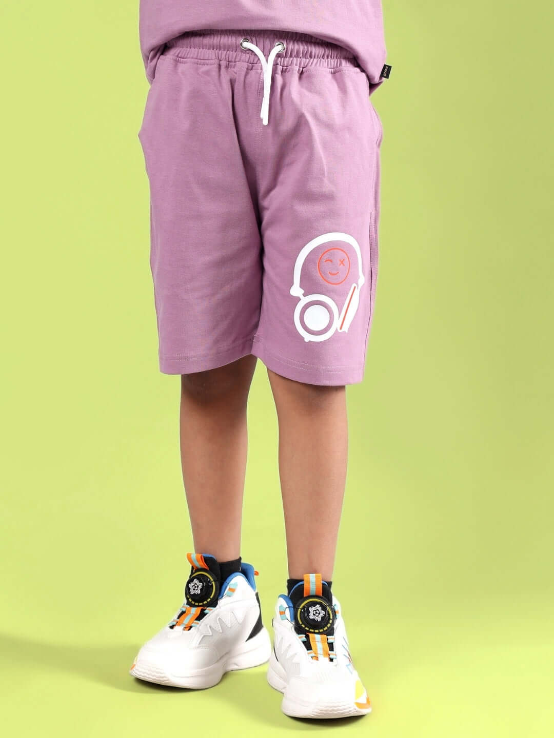 Child wearing STOIC SHORTS FOR BOYS & GIRLS PULM PURPLE by DUDS with a smiley print on pocket, suitable for customization.