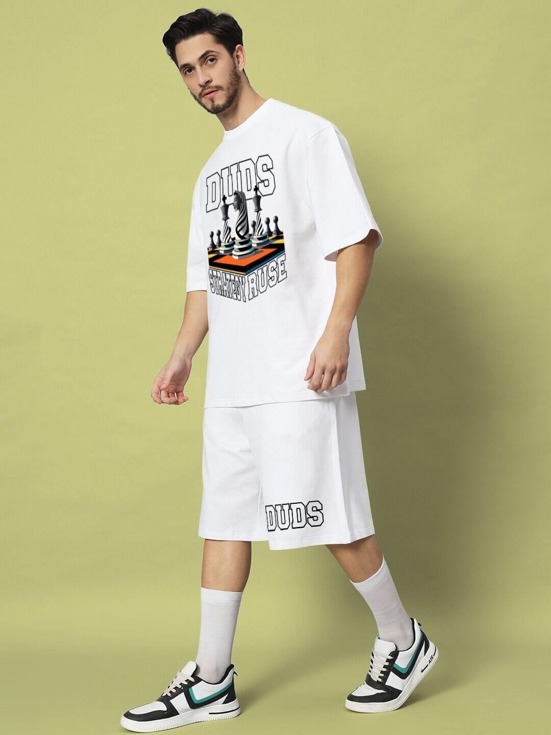 Model wearing STRATEGY RUSE CO-ORD SET WHITE oversized tee and shorts with bold graphic design, exemplifying modern streetwear fashion.