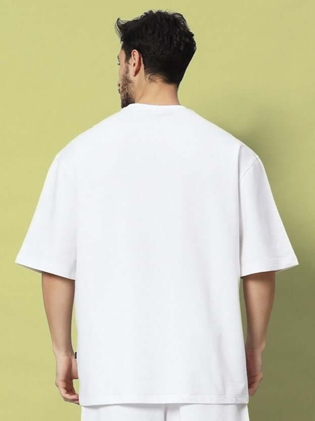 Back view of the STRATEGY RUSE OVER-SIZED T-SHIRT WHITE on a model, showcasing the minimalistic and streetwear style against a solid background.
