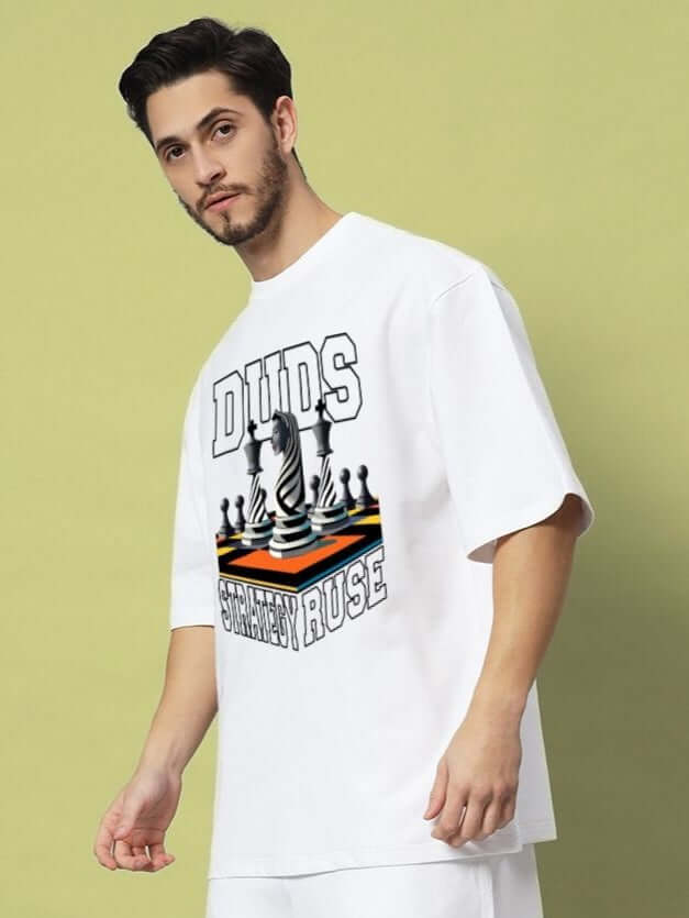 Model wearing STRATEGY RUSE OVER-SIZED T-SHIRT WHITE with bold graphic print, showcasing minimalist streetwear style.
