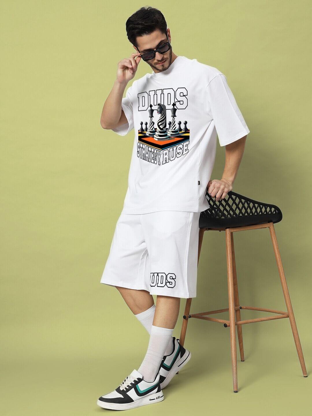 Person wearing STRATEGY RUSE OVER-SIZED T-SHIRT WHITE with graphic design, showcasing modern streetwear style and comfort.