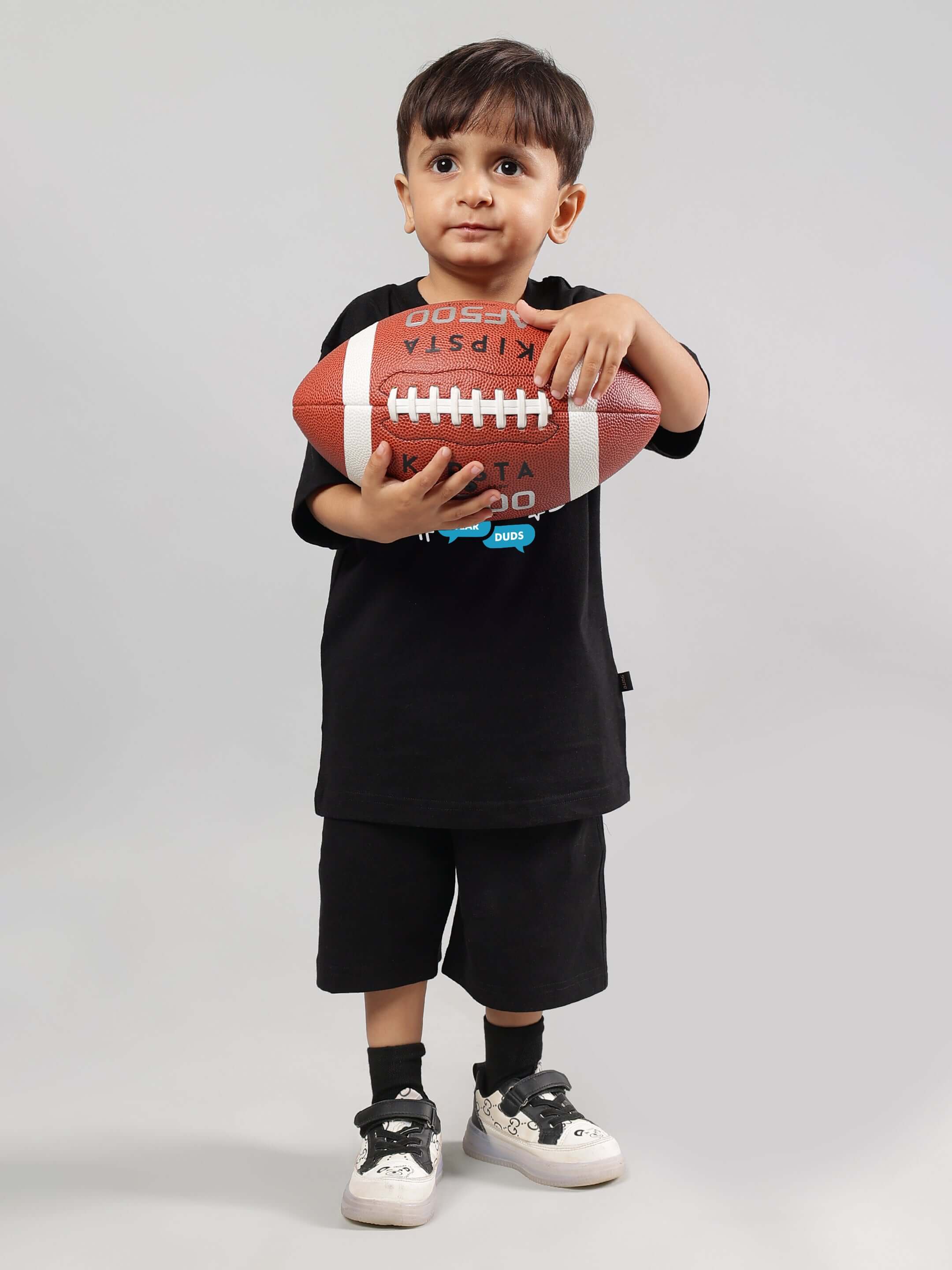 Toddler in black STREET TEAM CO-ORD outfit holding a football, designed for both boys and girls.