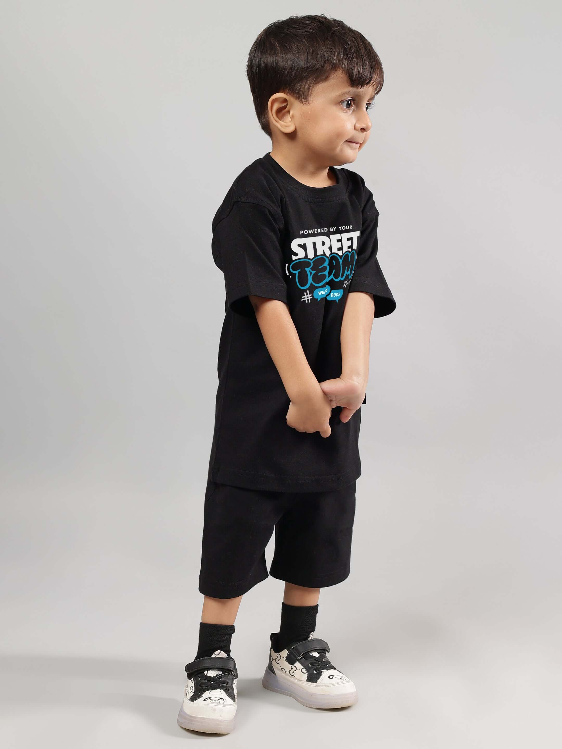 Boy wearing black Street Team T-shirt and shorts, designed for boys and girls. Comfortable, stylish, and customizable fit by DUDS.