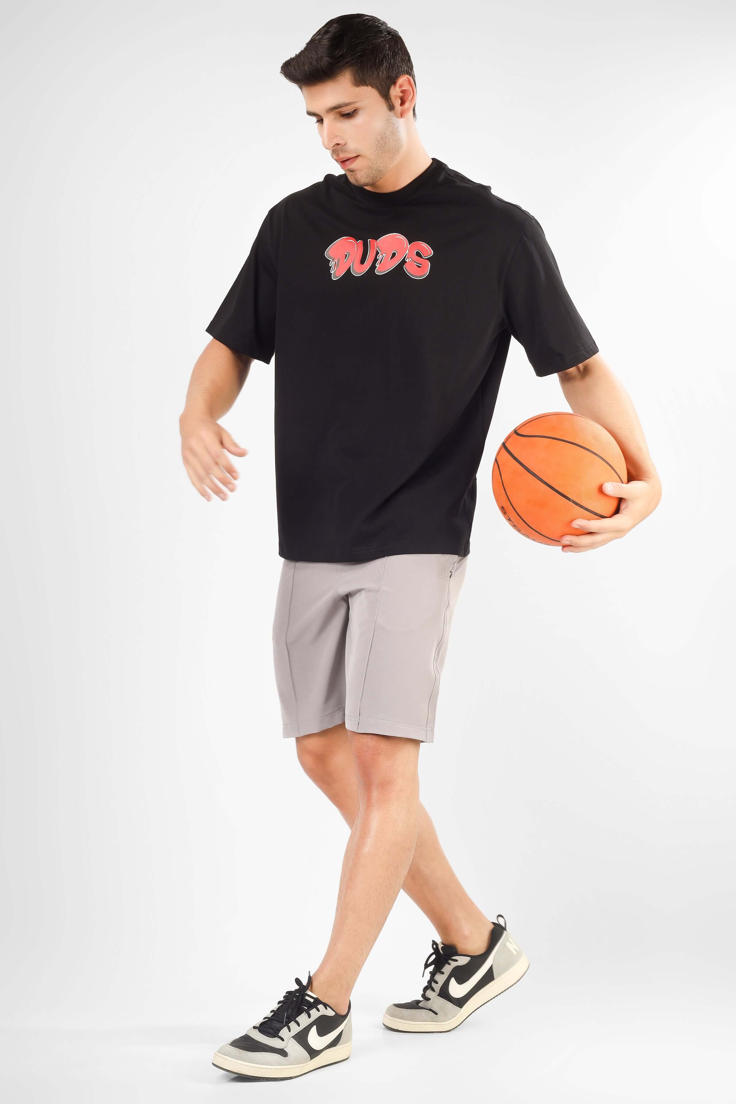 Man wearing STURDY FRONT PLATED SHORTS GREY playing basketball indoors.