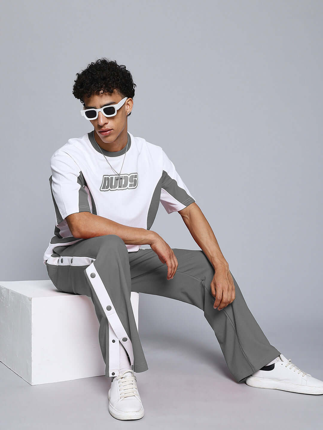 Model wearing grey EZEL Relaxed Fit Jogger with white sneakers, showcasing casual fashion from DUDS.