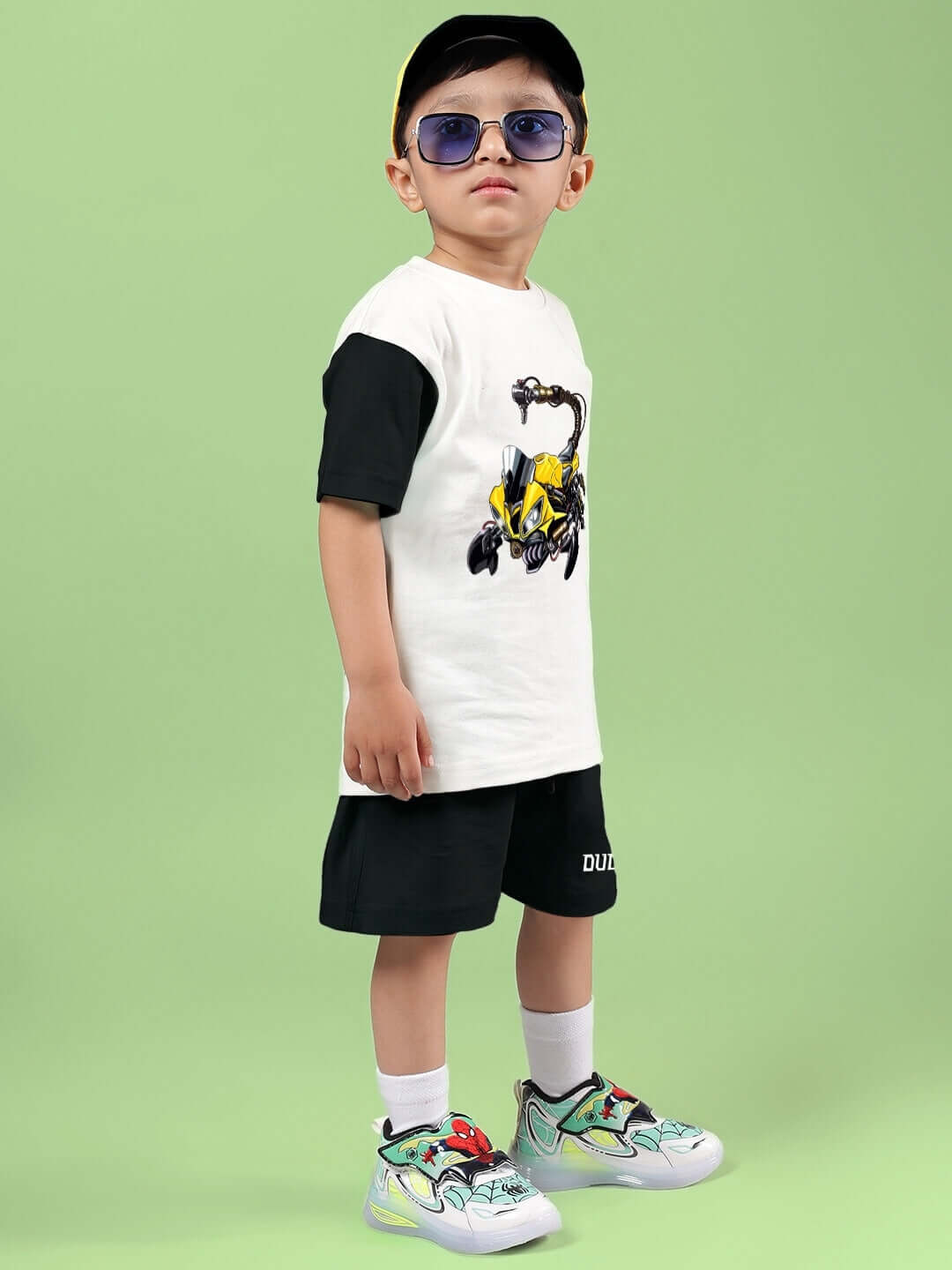 Child wearing STYLISH ROBOT CO-ORD FOR BOYS & GIRLS OFF WHITE BLACK with robot-printed t-shirt and shorts, showcasing playful design.