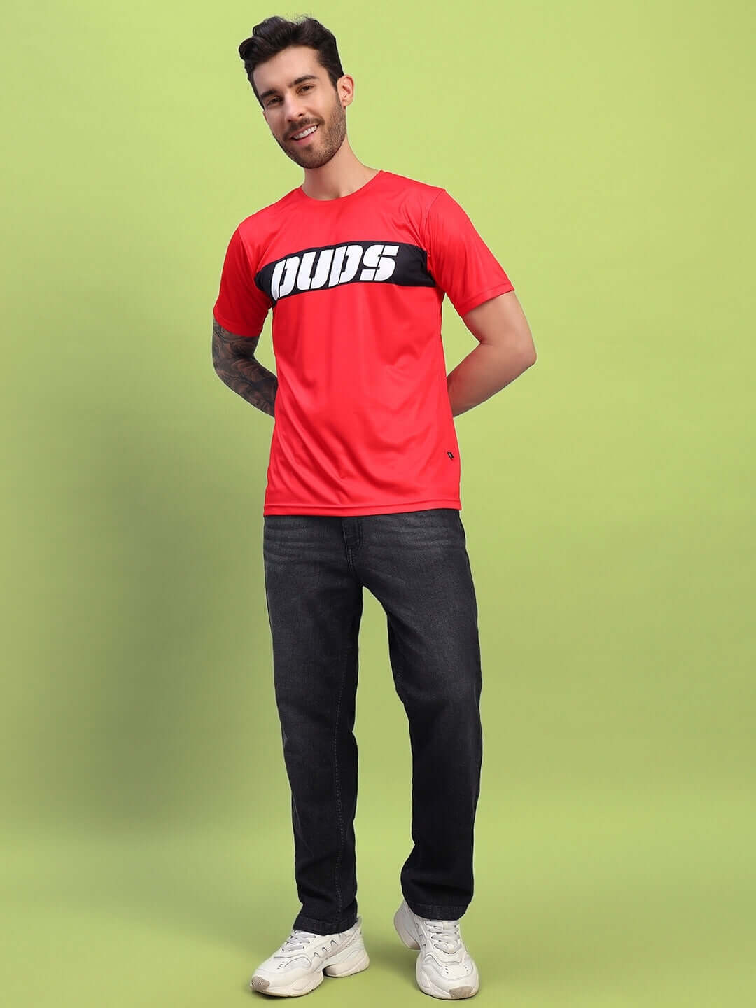 Model wearing a red stylized leopard printed t-shirt in sports polyester fabric on green background
