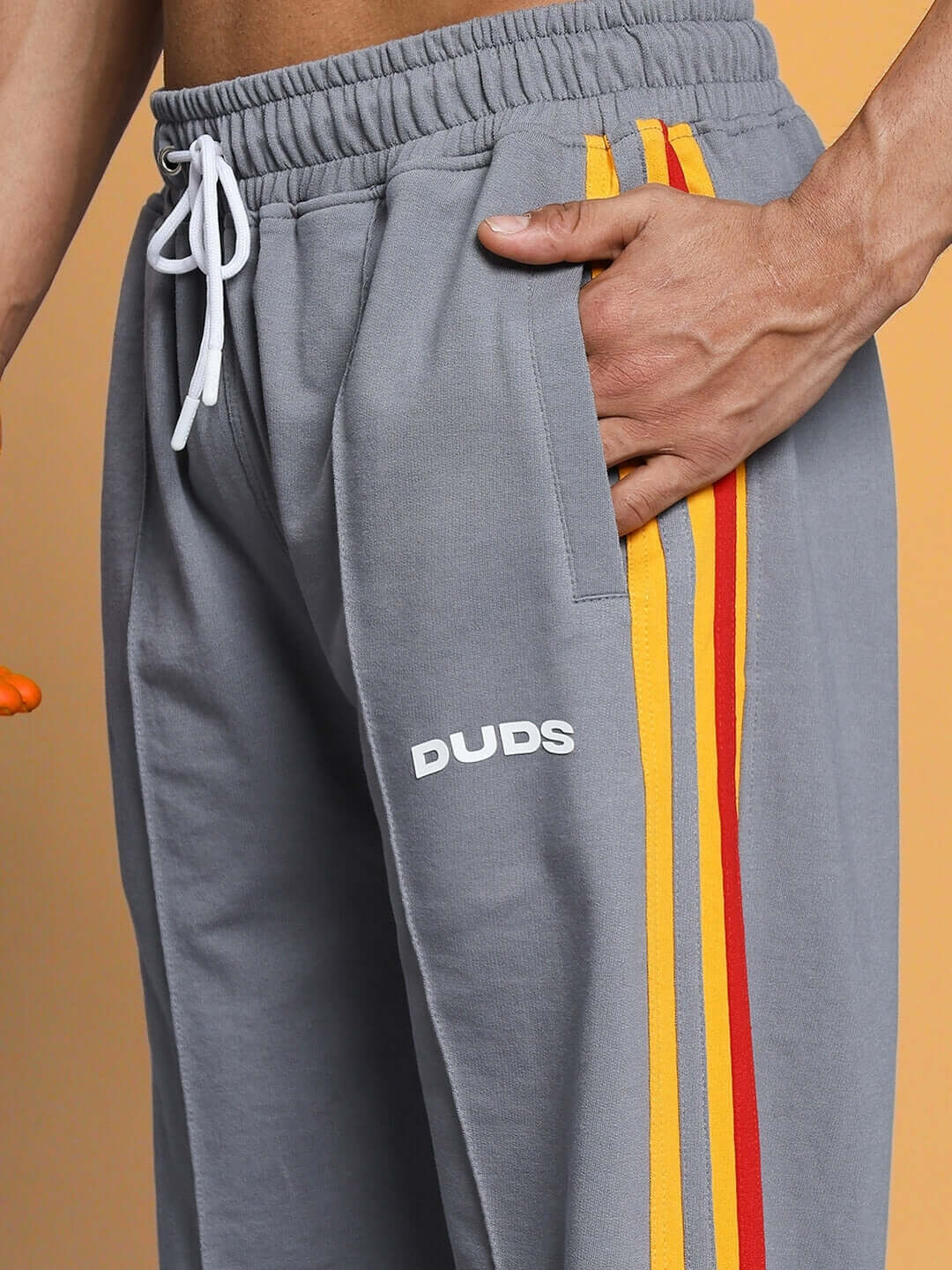 Grey SUNSHINE STRIPE JOGGER by DUDS with yellow and red side stripes, tailored fit, shown with elastic waistband and white drawstring.