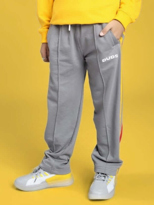 SUNSHINE STRIPE JOGGER FOR BOYS AND GIRLS RED GREY shown with grey pants and a yellow background.