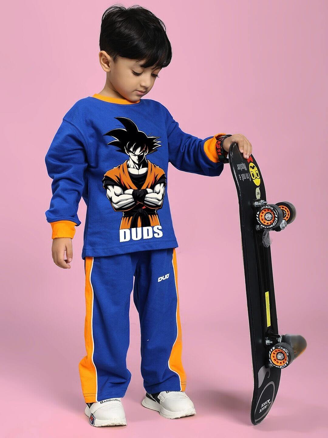 Child wearing SUPER SAIYAN CO-ORD SET FOR BOYS AND GIRLS BLUE with skateboard on pink background.